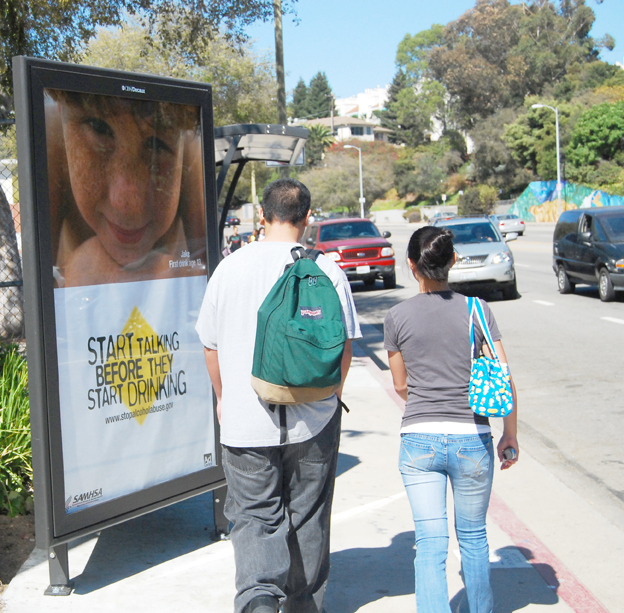 Two students pass a controversial new bus bench/advertising kiosk outside Palisades Charter High School on Temescal Canyon Road.